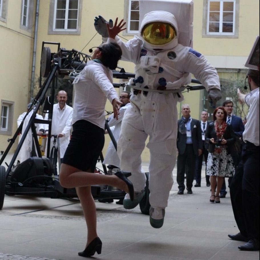 Une femme en tailleur court en sautant près d'un astronaute en combinaison spatiale.