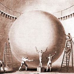 Des hommes en train de manipuler une grande sphère sur des échelles.