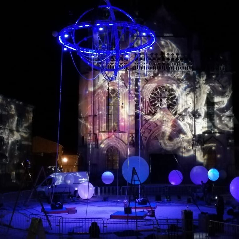 Spectacle nocturne avec feux d'artifice et foule illuminée.