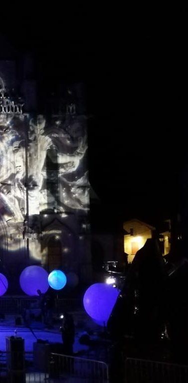 Projection artistique sur un mur avec des sphères lumineuses colorées en première plan.