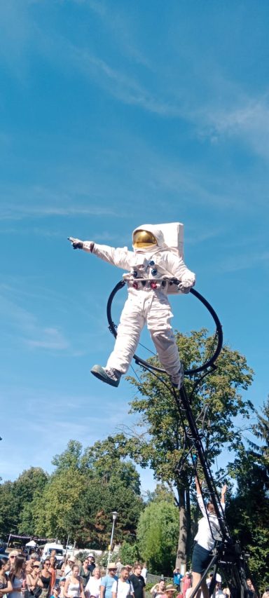 Un astronaute en tenue flottant dans les airs, pointant vers le ciel.