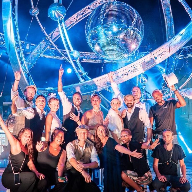 Groupe d'artistes cabaretsouriantes en fête avec une boule à facettes en arrière-plan.