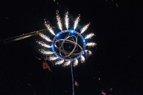 Fusée de feu d'artifice en forme de cercle avec étincelles brillantes sur fond noir.