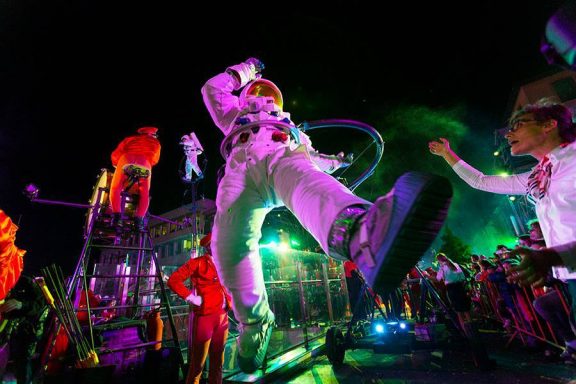 Astronaute en costume spacieux au milieu d'une fête avec des lumières colorées.