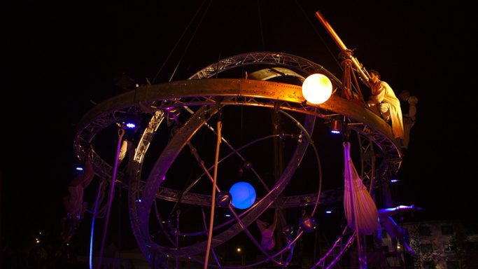 Sculpture d'astronomie éclairée, représentant un système solaire avec planètes.