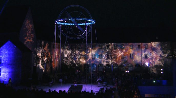 Scène nocturne avec des projections lumineuses sur un bâtiment historique.