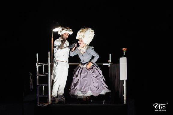 Deux performers sur scène, habillés de manière extravagante, en pleine performance.