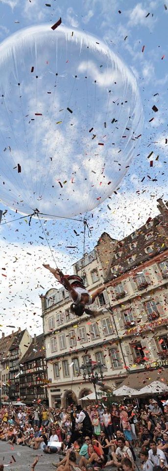 Une performance acrobatique en plein air avec des spectateurs et des confettis.